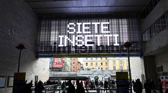 “Siete insetti” sui tabelloni delle stazioni ferroviarie di Milano e Roma, svelato l’arcano
